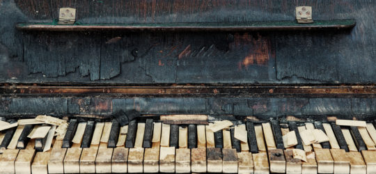 an old broken junk piano